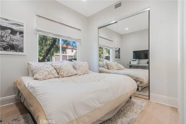a bedroom with a large bed and a flat tv screen
