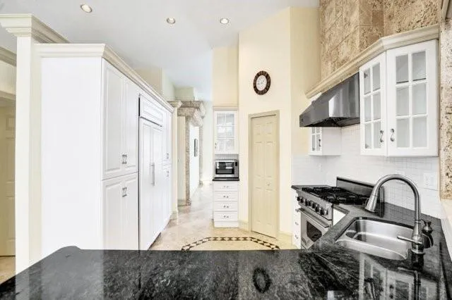 a kitchen with stainless steel appliances granite countertop a stove a sink and a refrigerator