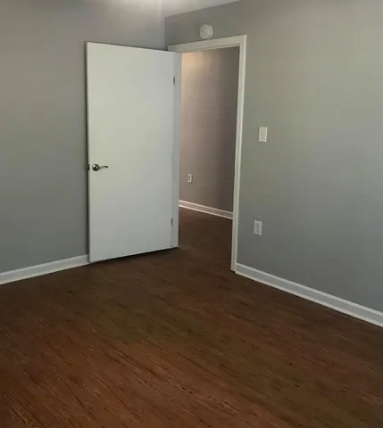 an empty room with wooden floor and closet