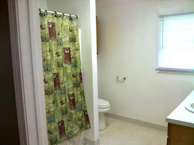 a bathroom with a toilet and a shower
