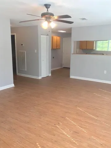 a view of a big room with wooden floor and windows