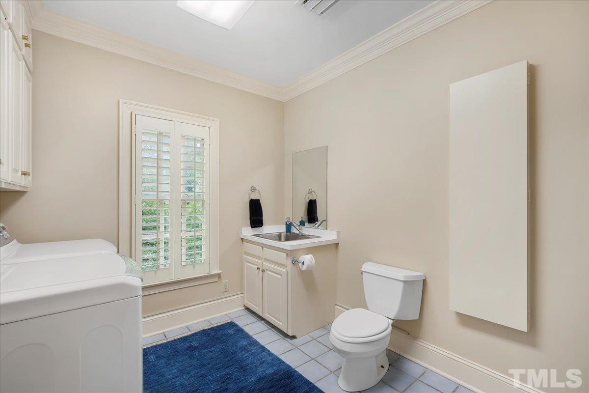 1213 Marlowe Road Raleigh, NC 27609 - Photo 20 of 30 a bathroom with a sink a toilet and a window