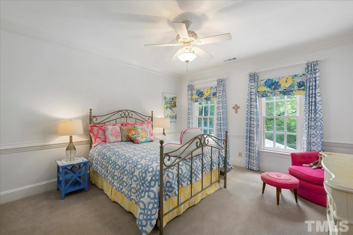 1213 Marlowe Road Raleigh, NC 27609 - Photo 27 of 30 a bedroom with a bed and a chandelier