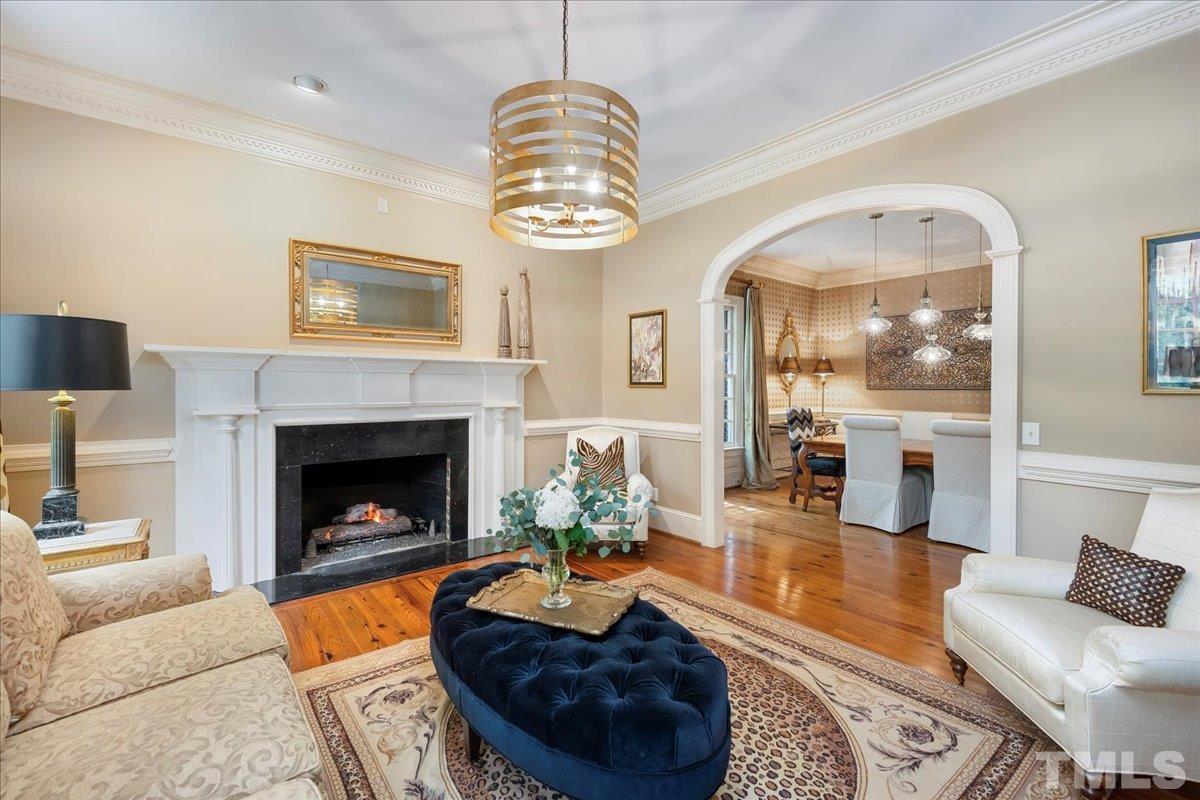 1213 Marlowe Road Raleigh, NC 27609 - Photo 5 of 30 a living room with furniture a chandelier and a fireplace