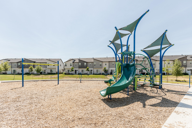 349 West 3085 South Logan, UT 84321 - Photo 34 of 37 Community playground featuring a multi-level play structure with slide, climbing elements, and shade canopies over a wood chip surface