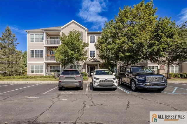a front view of a house with cars parked