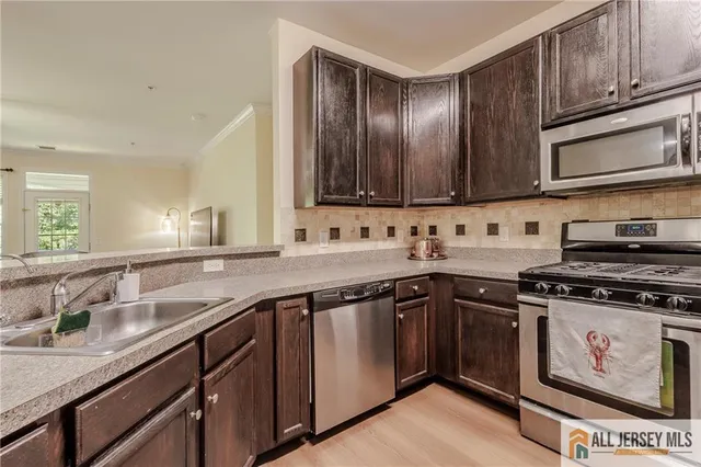 a kitchen with stainless steel appliances granite countertop a sink and a stove