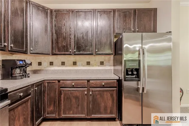 a kitchen with a sink a refrigerator and cabinets