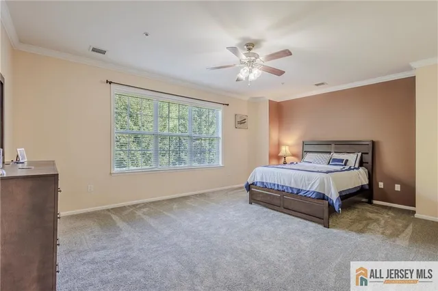 a spacious bedroom with a bed and a chandelier
