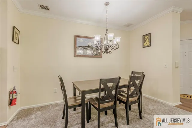 a view of a dining room with furniture and chandelier