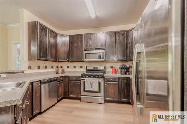 a kitchen with stainless steel appliances granite countertop a stove and a sink
