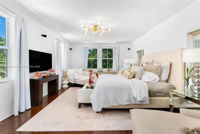 a bedroom with a large bed and a chandelier