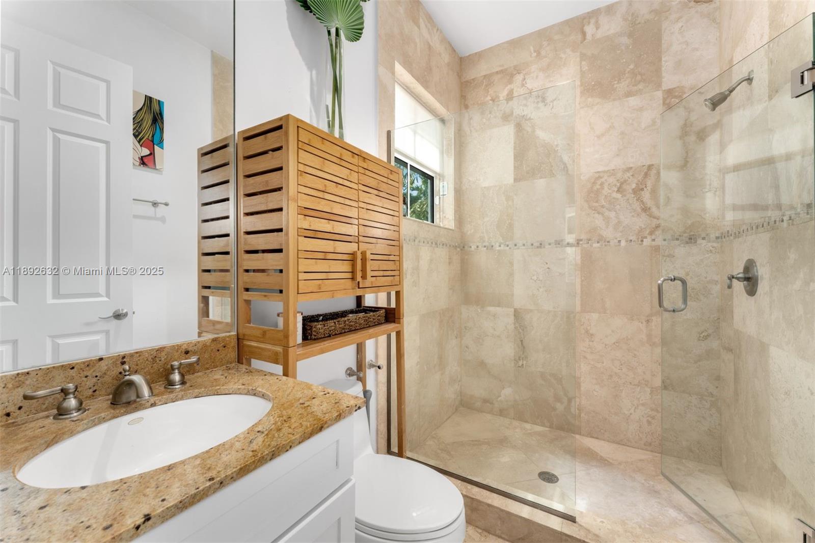 2143 North Bay Road Miami Beach, FL 33140 - Photo 35 of 39 a bathroom with a granite countertop sink toilet a mirror and shower