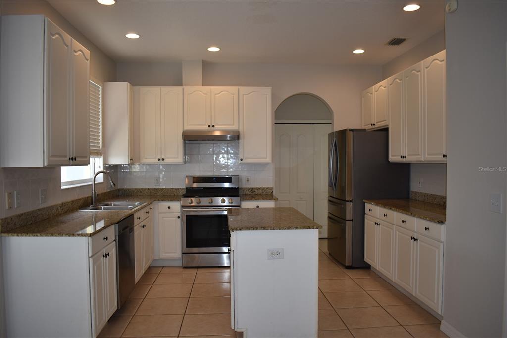 15509 Montilla Loop Tampa, FL 33625 - Photo 3 of 20 a kitchen with kitchen island granite countertop a stove sink and refrigerator