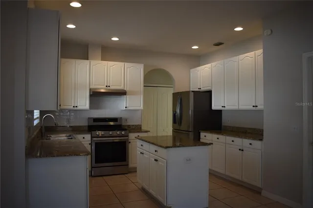 a kitchen with stainless steel appliances granite countertop a refrigerator and a stove