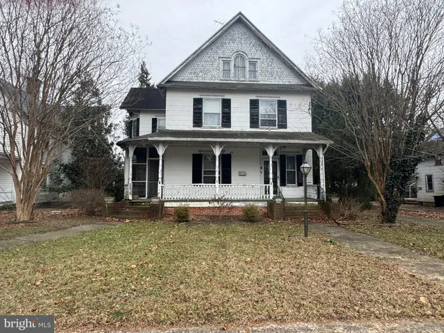 a view of a yard in front of a house with large windows