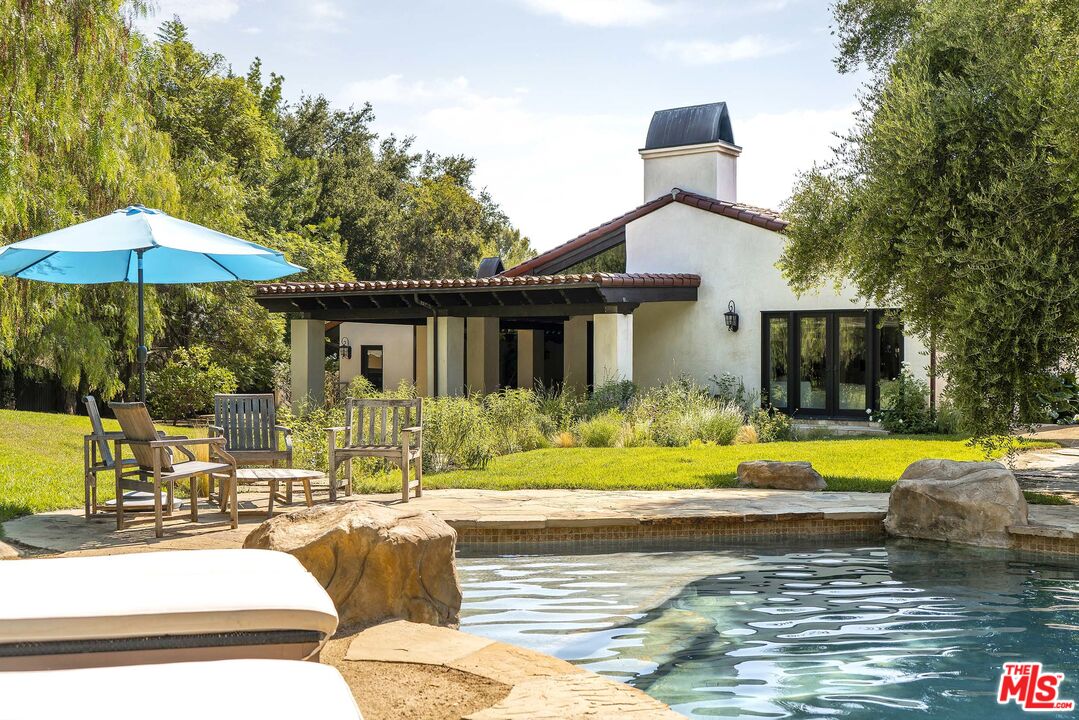 2251 Cold Canyon Road Calabasas, CA 91302 - Photo 3 of 47 a view of a house with pool and chairs under an umbrella