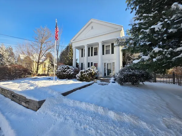 a front view of a house with yard and tree s