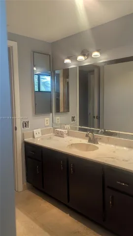 a bathroom with double vanity sinks and a large mirror