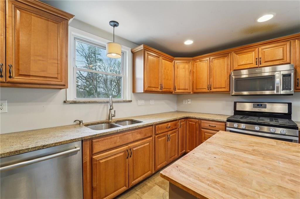 6012 Cunningham Road Gibsonia, PA 15044 - Photo 7 of 26 a kitchen with stainless steel appliances granite countertop a sink a stove and cabinets