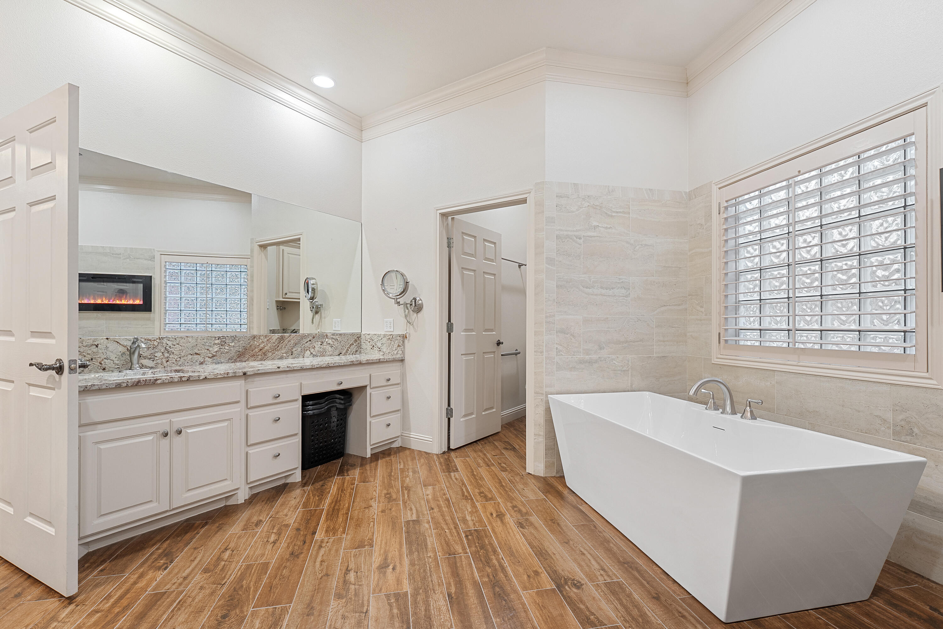 7502 Norfolk Avenue Lubbock, TX 79423 - Photo 24 of 41 a spacious bathroom with a granite countertop sink mirror and a bathtub
