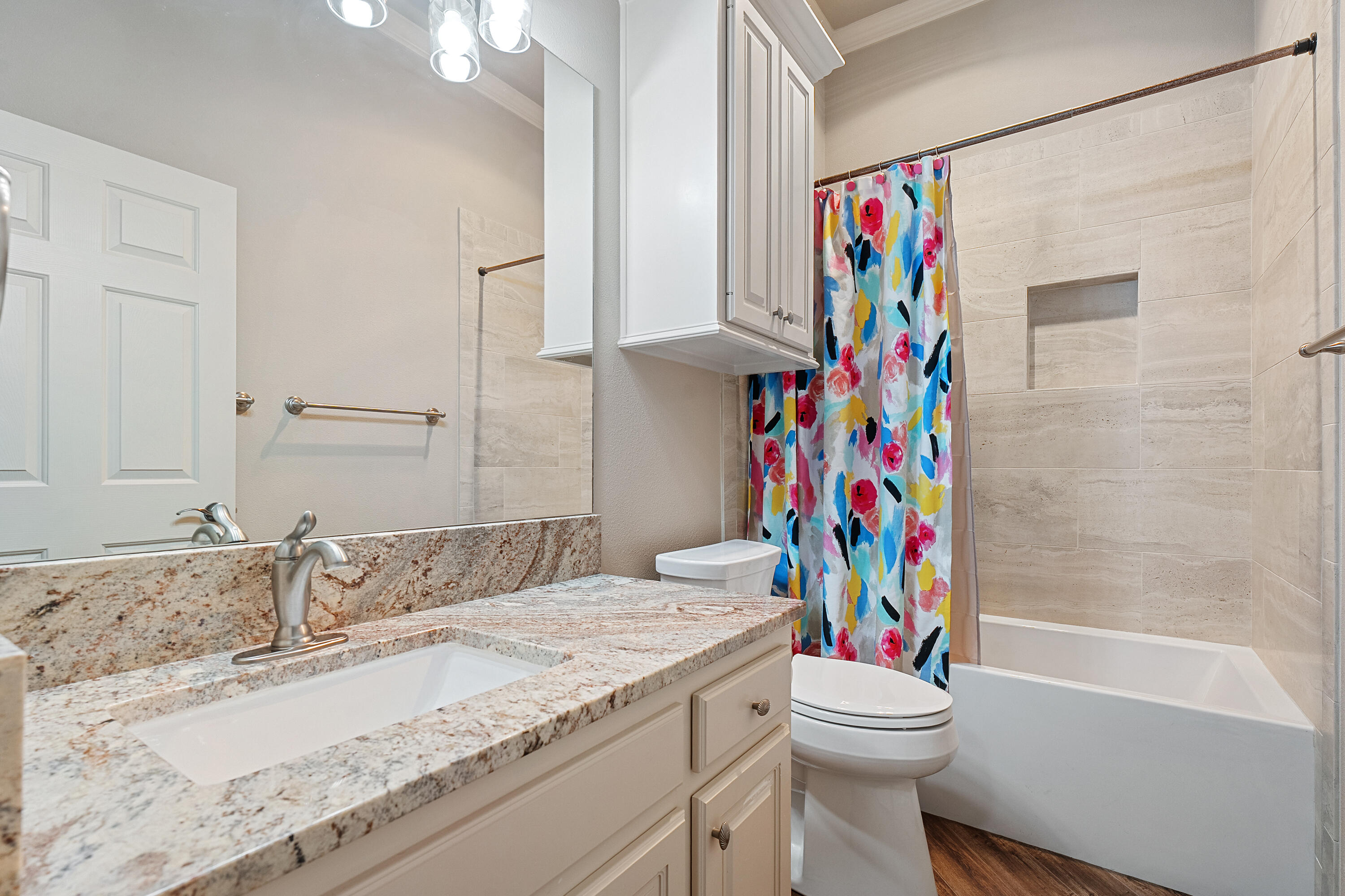 7502 Norfolk Avenue Lubbock, TX 79423 - Photo 29 of 41 a bathroom with a sink a toilet and a shower curtain