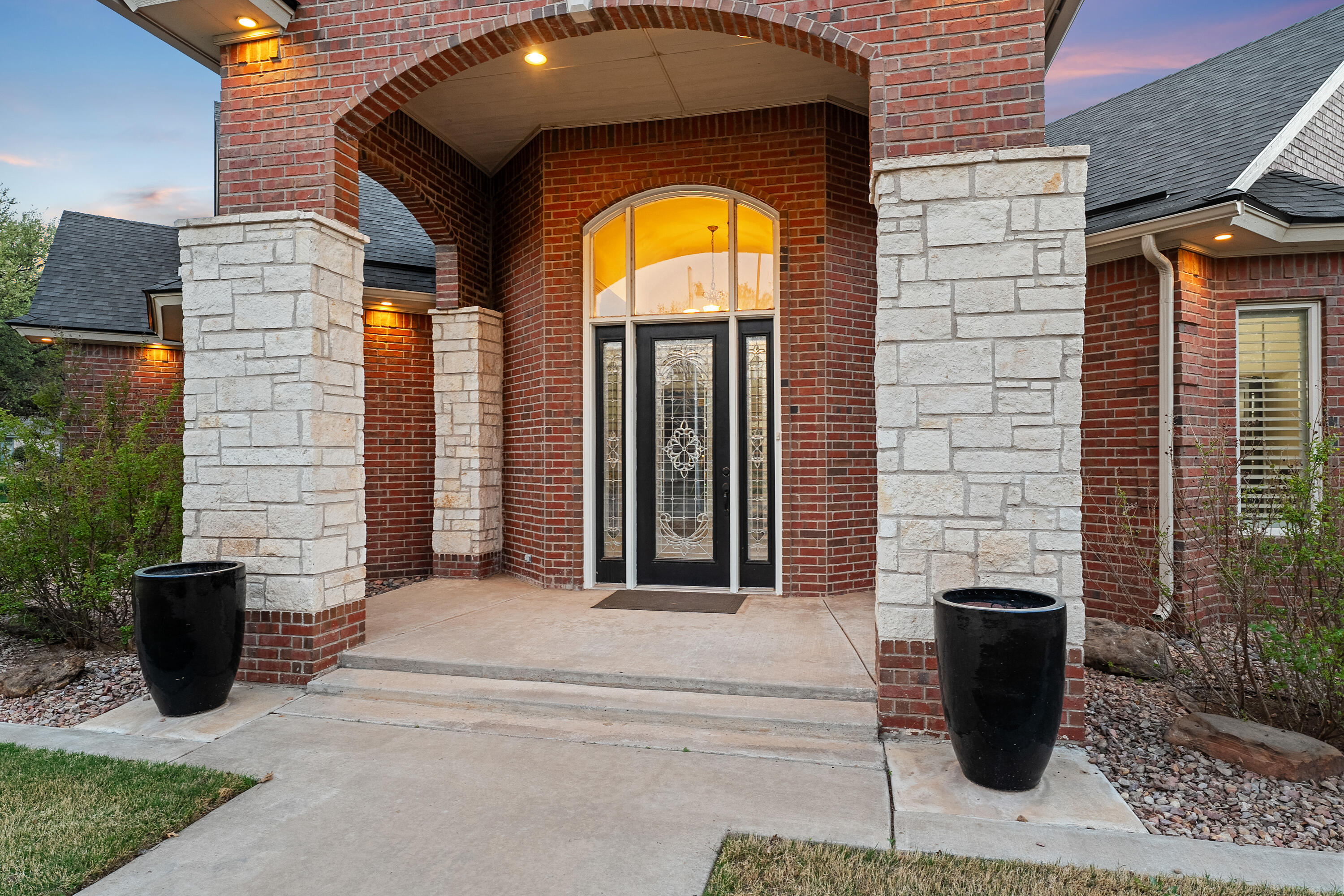 7502 Norfolk Avenue Lubbock, TX 79423 - Photo 3 of 41 a view of a brick house with potted plants