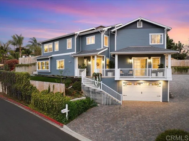 a front view of a house with a yard and potted plants