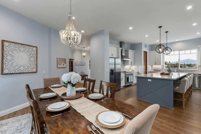a dining room with furniture a chandelier and wooden floor