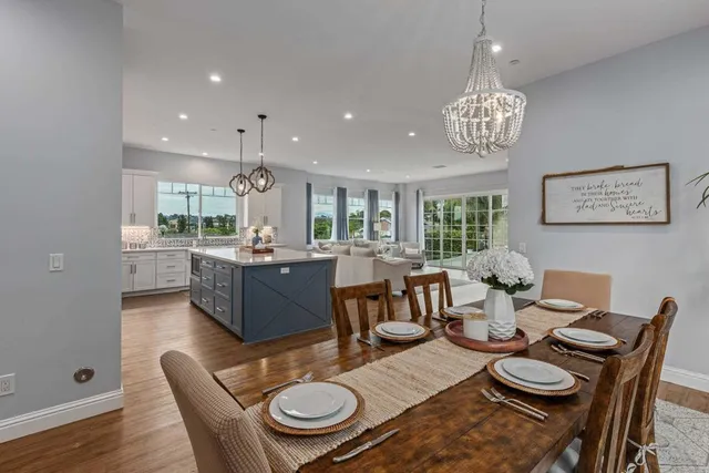 a view of a dining room with furniture a rug and wooden floor