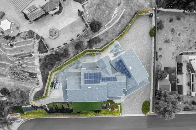 an aerial view of a house with a yard and large trees