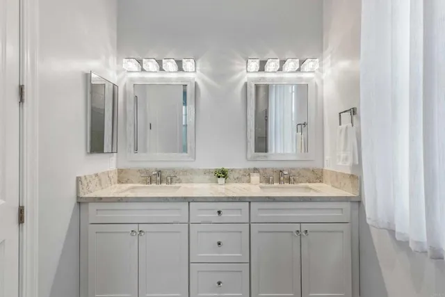 a bathroom with double sink and a mirror