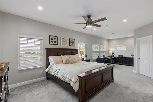 a spacious bedroom with a large bed and a chandelier