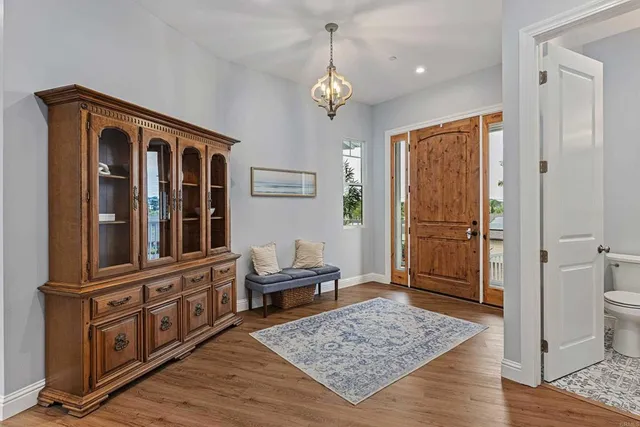 a view of a hallway with wooden floor and windows