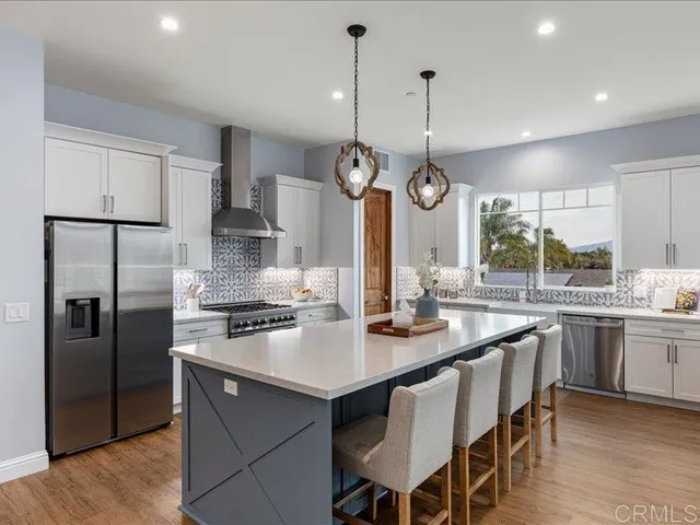 a kitchen with kitchen island granite countertop a sink a center island stainless steel appliances and cabinets