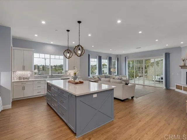 a kitchen with counter top space sink stove and wooden floor