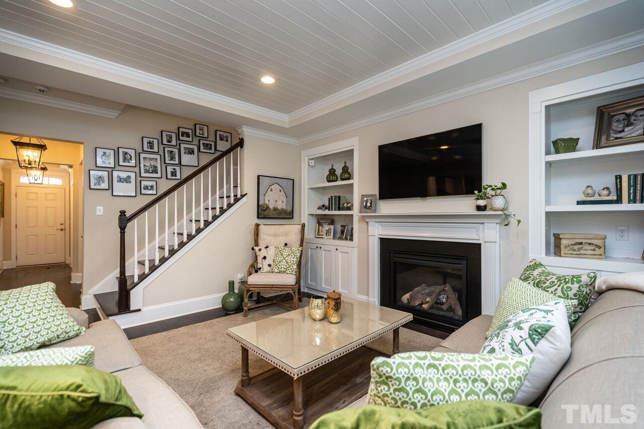 4013 Windflower Lane Raleigh, NC 27612 - Photo 8 of 28 a living room with furniture a flat screen tv and a fireplace