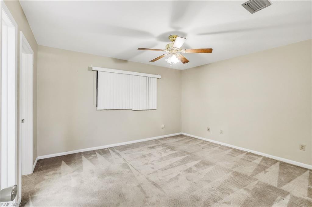 5290 Cypress Lane Naples, FL 34113 - Photo 16 of 39 an empty room with a window and a ceiling fan
