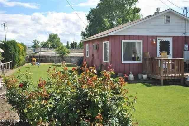 1114 Viall Road Grandview, WA 98930 - Photo 1 of 5 a backyard of a house with yard table and chairs