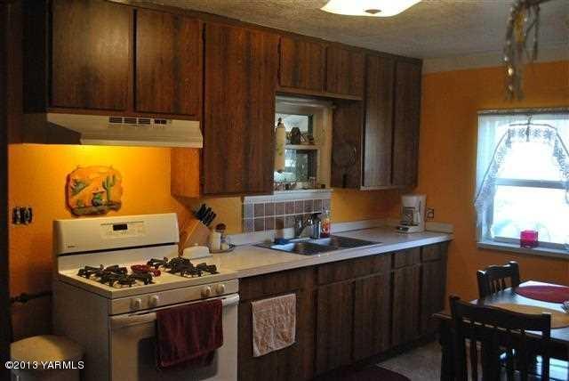 1114 Viall Road Grandview, WA 98930 - Photo 2 of 5 a kitchen with stainless steel appliances a stove a sink and a refrigerator
