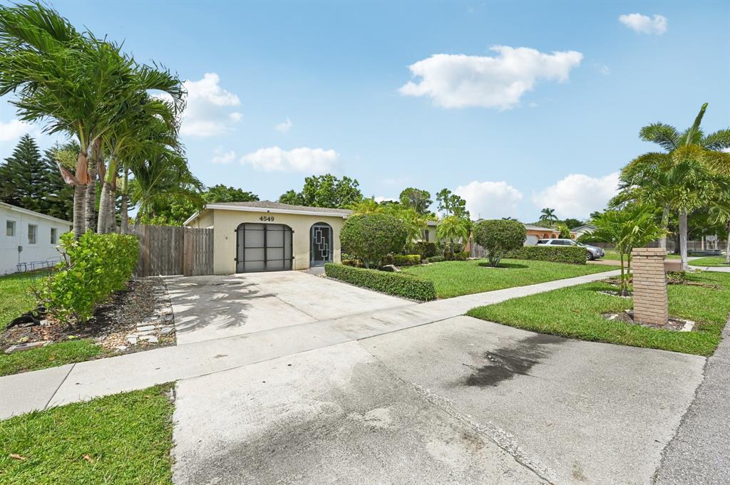 4549 Baldric Street Boca Raton, FL 33428 - Photo 18 of 43 a front view of a house with a yard and garage