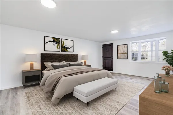 a bedroom with a bed and wooden floor