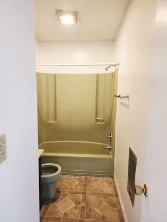 a bathroom with a toilet and shower