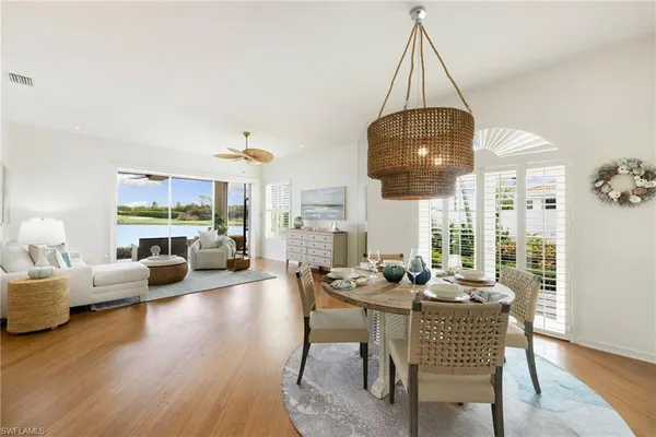 a dining room with furniture a chandelier and wooden floor