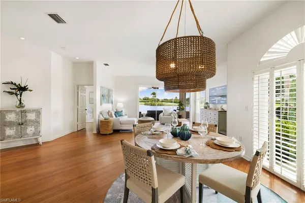 a dining room with furniture a chandelier and wooden floor