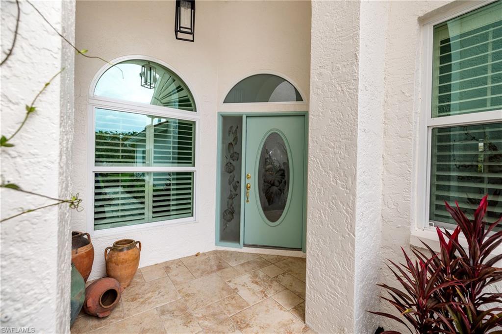 2153 Paget Circle Naples, FL 34112 - Photo 33 of 49 Property entrance with stucco siding and a patio