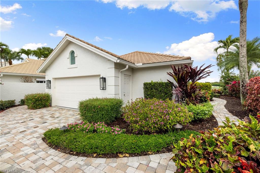 2153 Paget Circle Naples, FL 34112 - Photo 36 of 49 View of property exterior with stucco siding, a garage, decorative driveway, and a tile roof