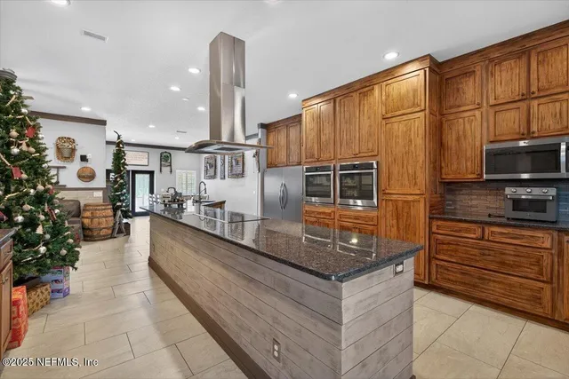 a kitchen with stainless steel appliances a sink a counter top space cabinets and a potted plant