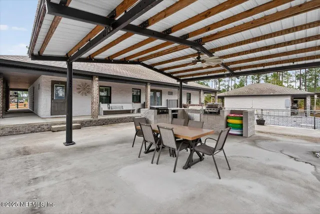 a view of a patio with a table and chairs under an umbrella