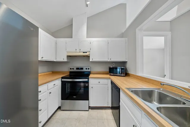 a kitchen with granite countertop white cabinets and white appliances